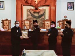 Marsono menyerahkan berita acara acara penetapan Raperda tentang Pertanggungjawaban Pelaksanaan APBD Tahun Anggaran 2019 dan tiga raperda lainnya pada Bupati Maryoto Birowo, dalam rapat paripurna DPRD Tulungagung, Senin (13/7).