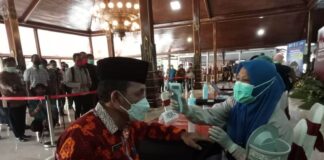Petugas mengukur suhu tubuh Marsono sebelum kemudian juga mengukur tensi darahnya saat acara Pencanangan Vaksinasi Covid-19 di Pendopo Kongas Arum Kusumaning Bongso, Kamis (28/1).