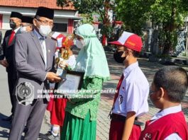 Marsono menyerahkan piagam penghargaan dan piala pada salah satu siswa berprestasi di upacara peringatan Hardiknas, Jumat (13/5).