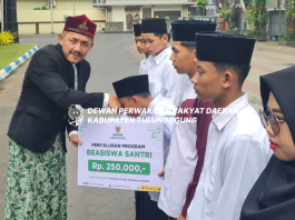 Marsono menyerahkan bea siswa pendidikan dari Baznas Tulungagung pada salah seorang santri saat Apel Hari Santri Nasional Tahun 2024 di halaman Kantor Bupati Tulungagung, Selasa (22/10).