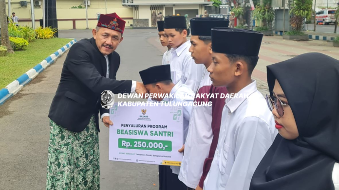 Marsono menyerahkan bea siswa pendidikan dari Baznas Tulungagung pada salah seorang santri saat Apel Hari Santri Nasional Tahun 2024 di halaman Kantor Bupati Tulungagung, Selasa (22/10).